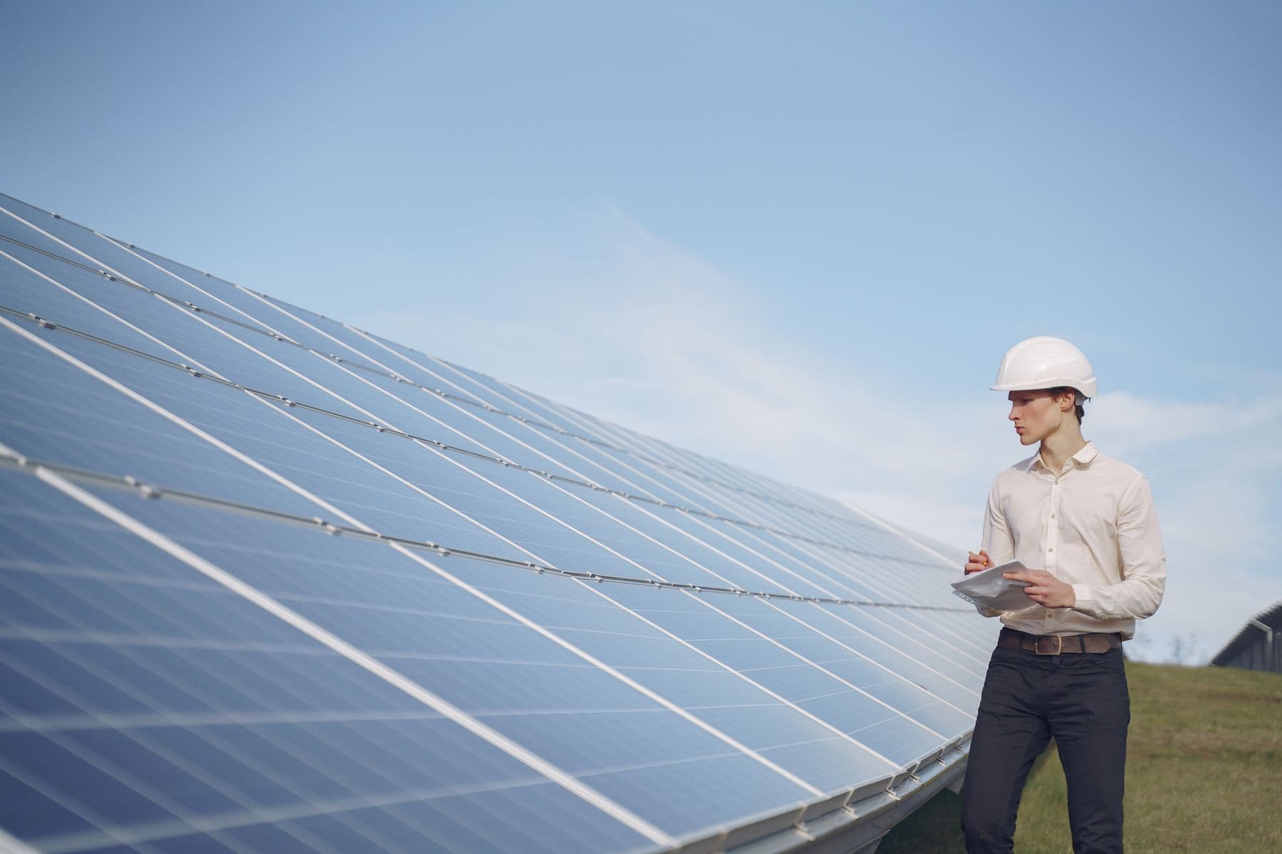 Solar technician inspecting a utility-scale photovoltaic array